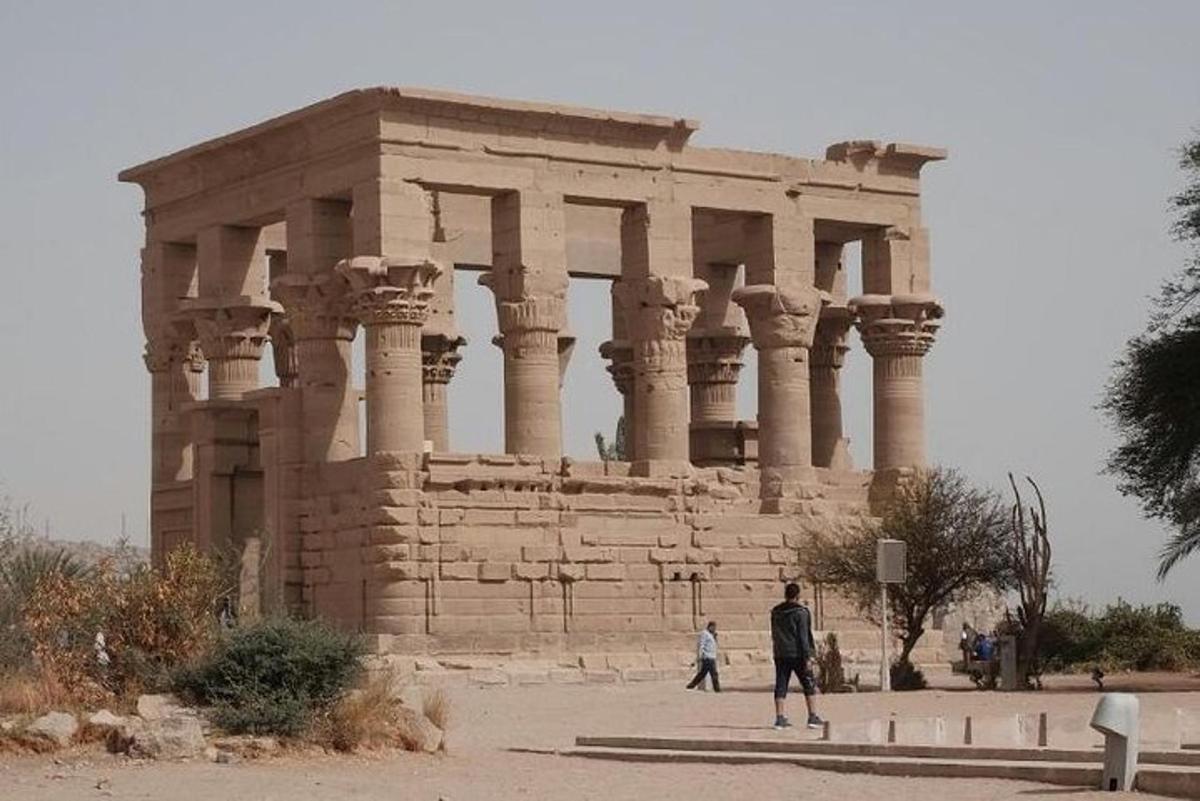 ένα πέτρινο κτίριο με ανθρώπους να περπατούν μπροστά του