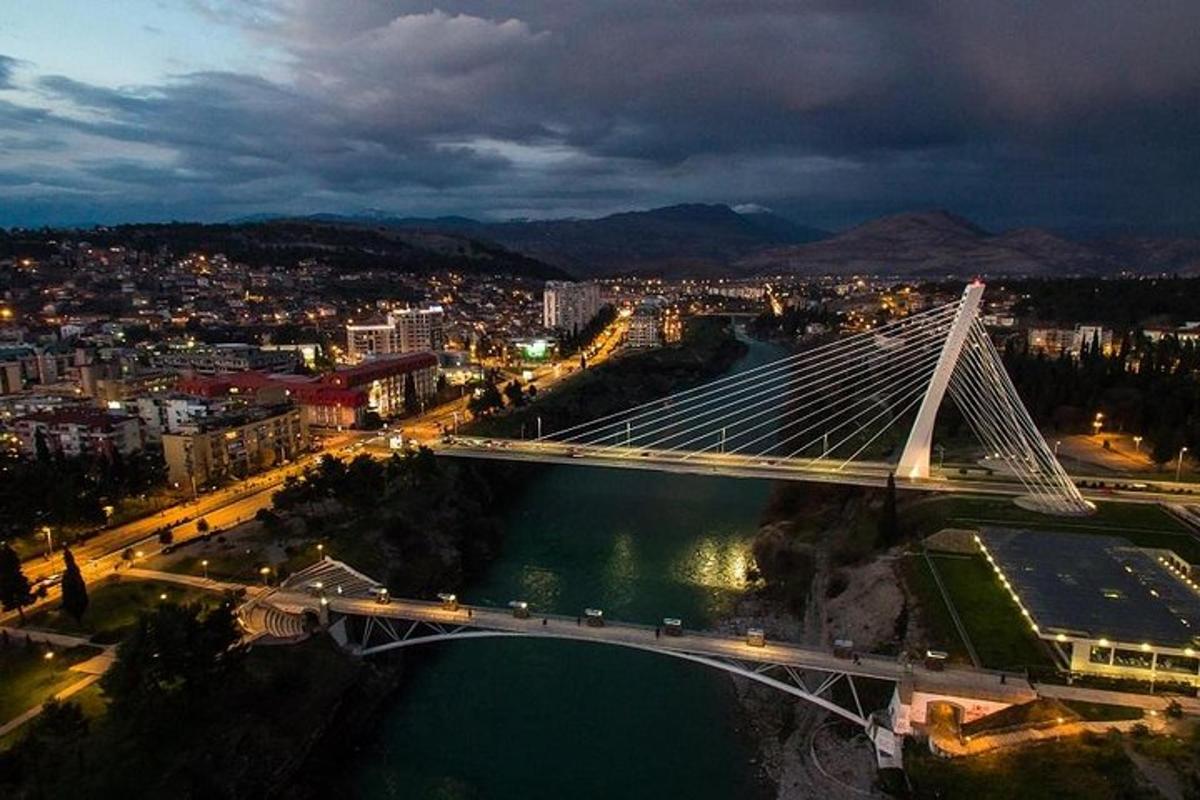 un pont sobre un riu amb una ciutat de nit