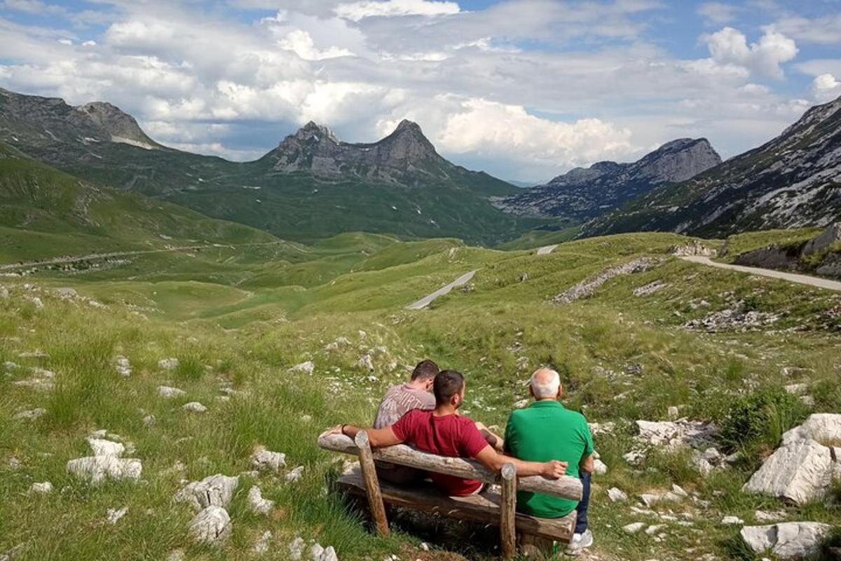 skupina treh ljudi, ki sedijo na klopi na polju
