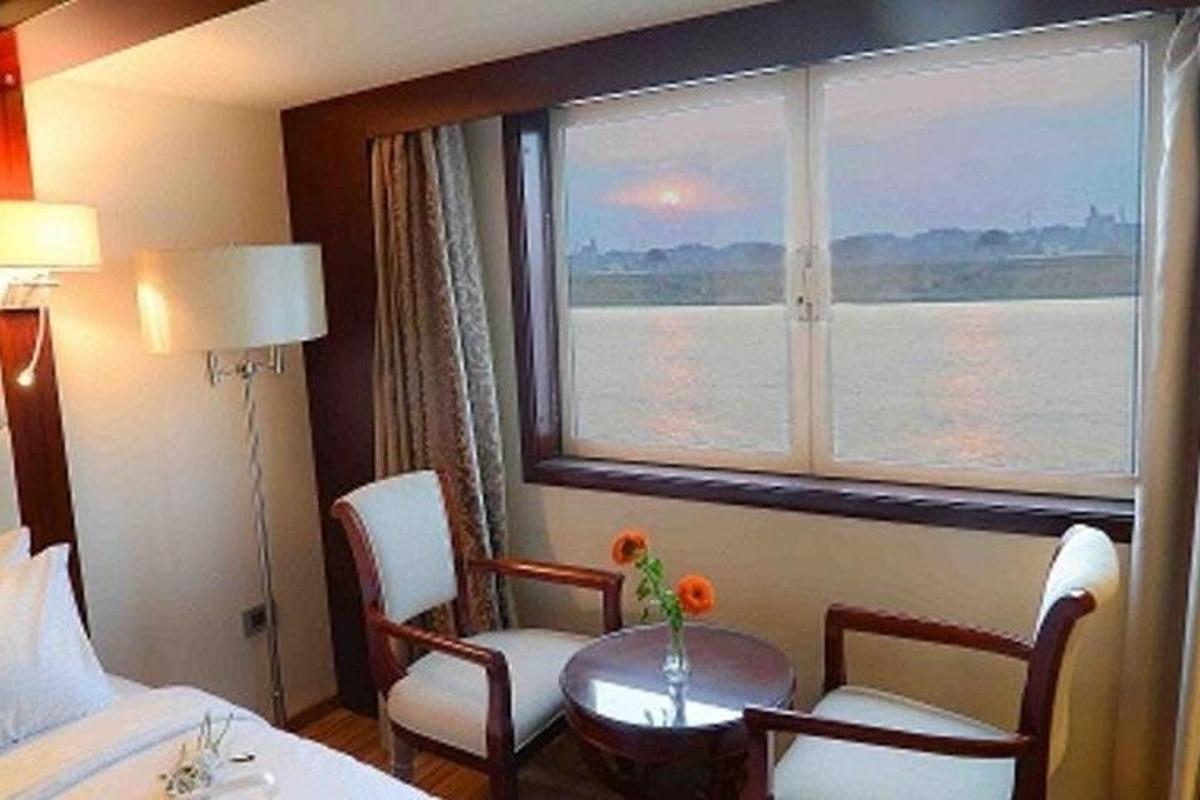 et hotellrom med et vindu og et bord og stoler