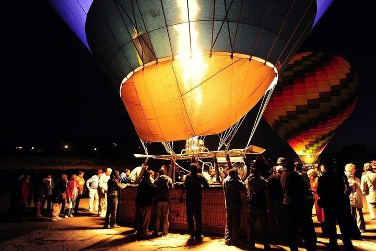 un grup de persones dempeus davant de dos globus aerostàtics