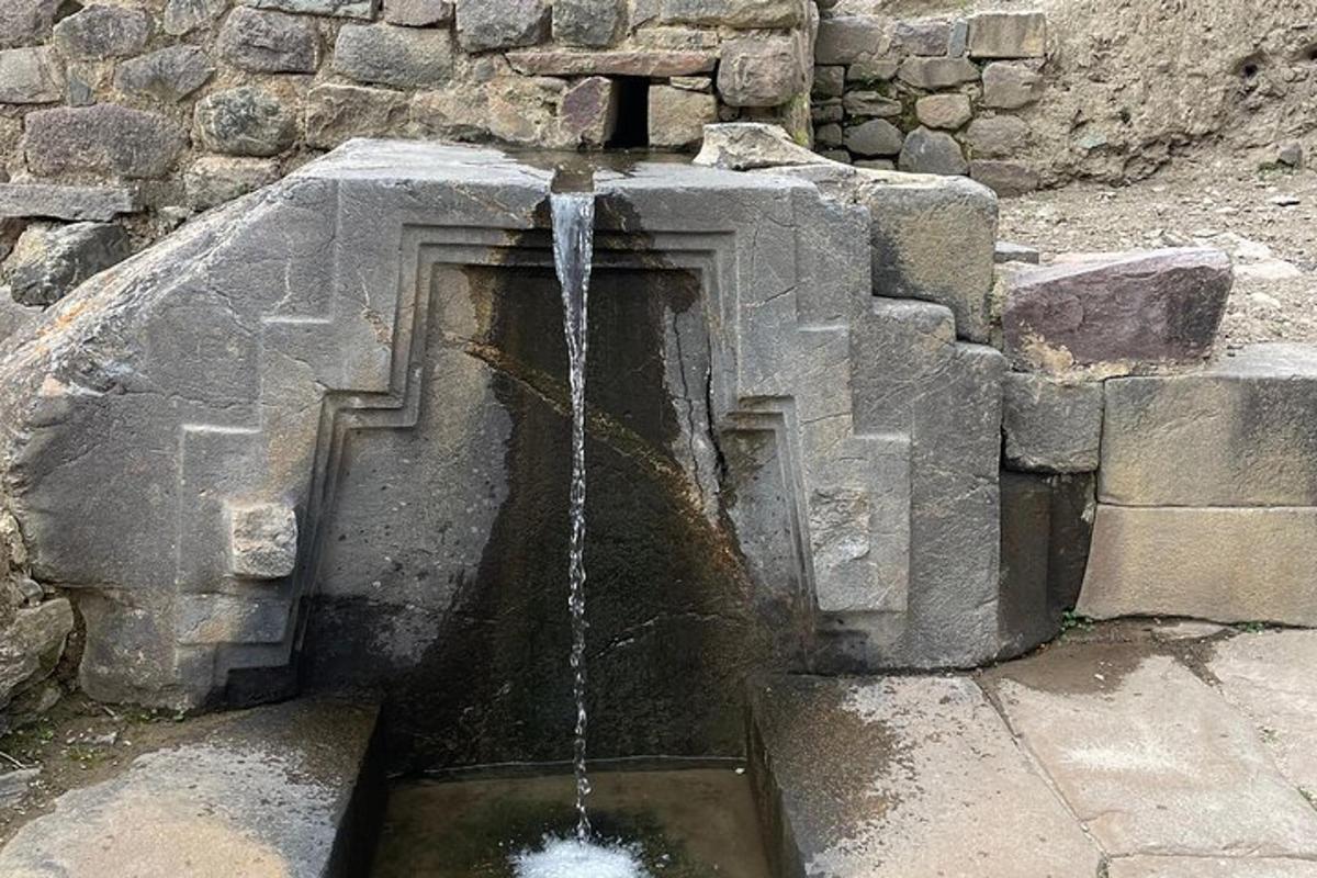 ein Wasserbrunnen vor einer Steinmauer