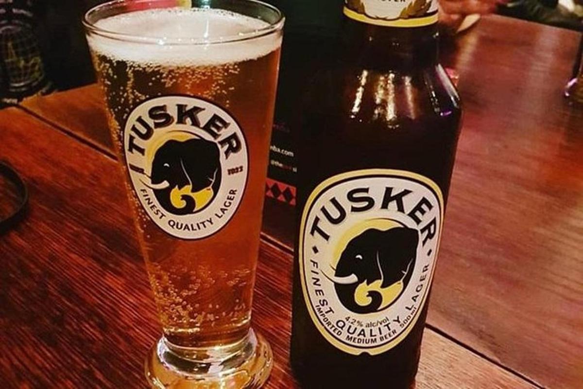 kozarec piva, ki sedi poleg steklenice piva