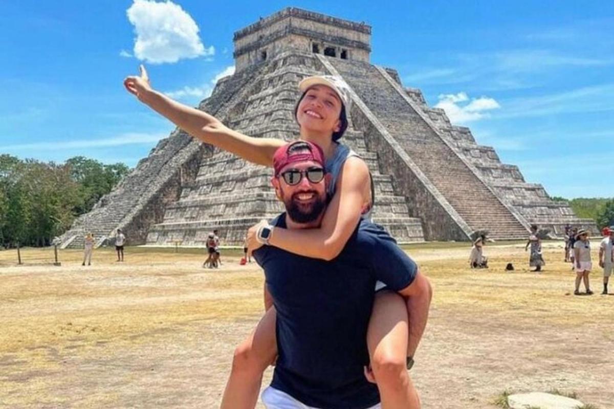 um homem segurando uma mulher em frente à pirâmide