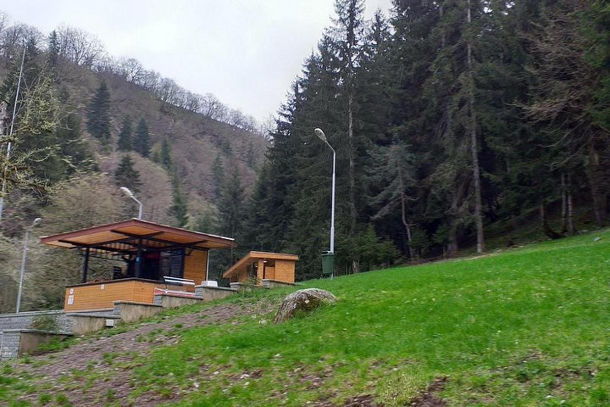 un piccolo edificio in cima a una collina erbosa