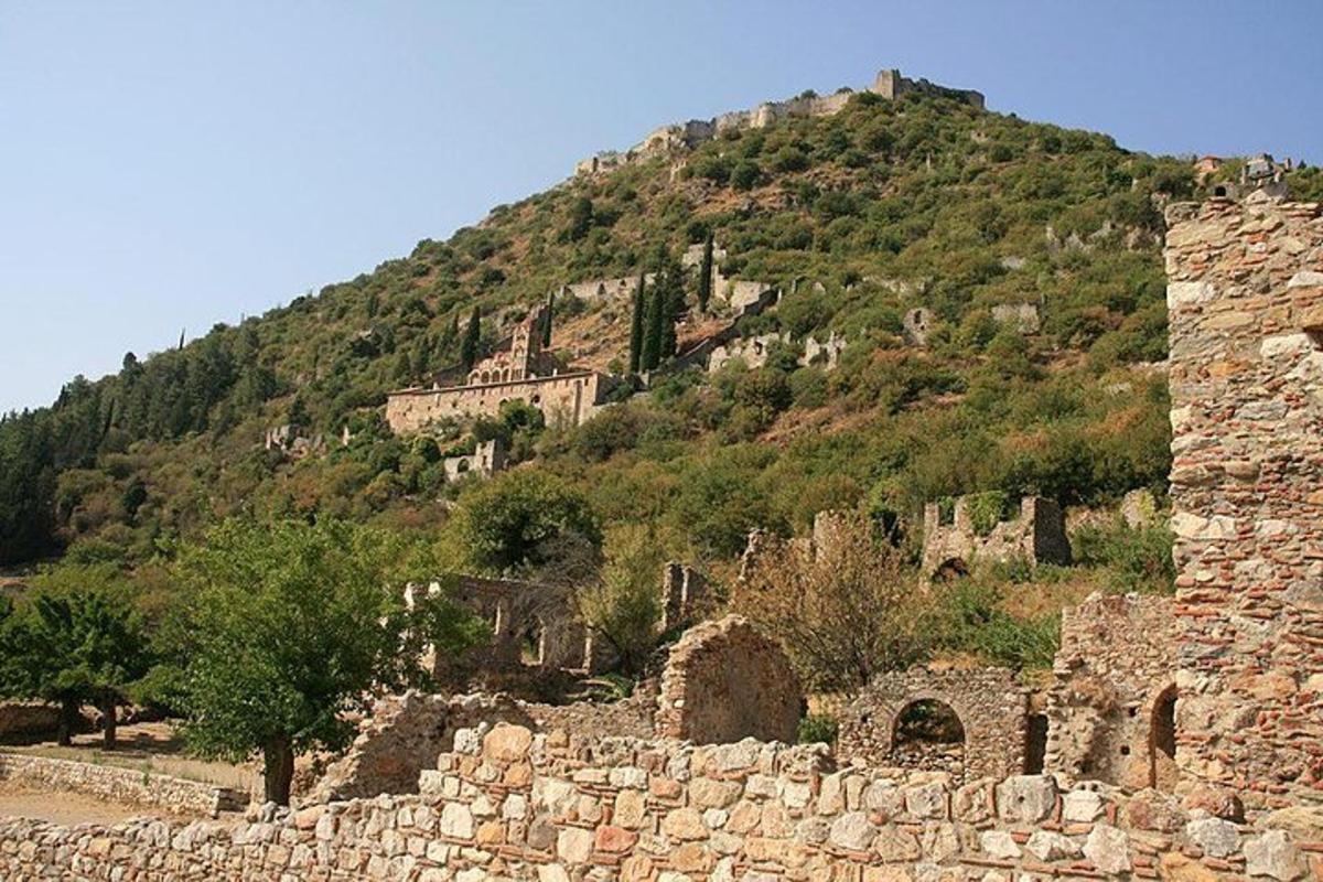 Un antiguo edificio de piedra con una montaña al fondo.