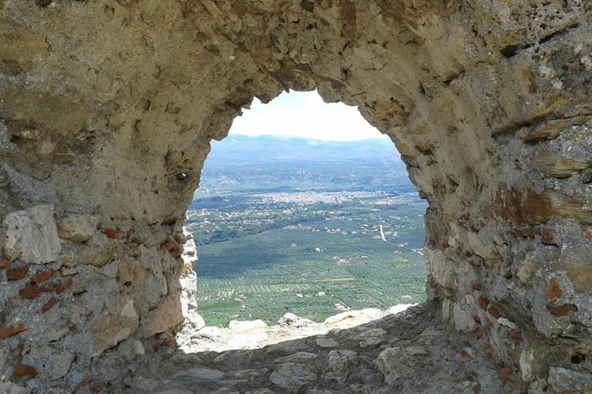 Una ventana en un muro de piedra con vistas