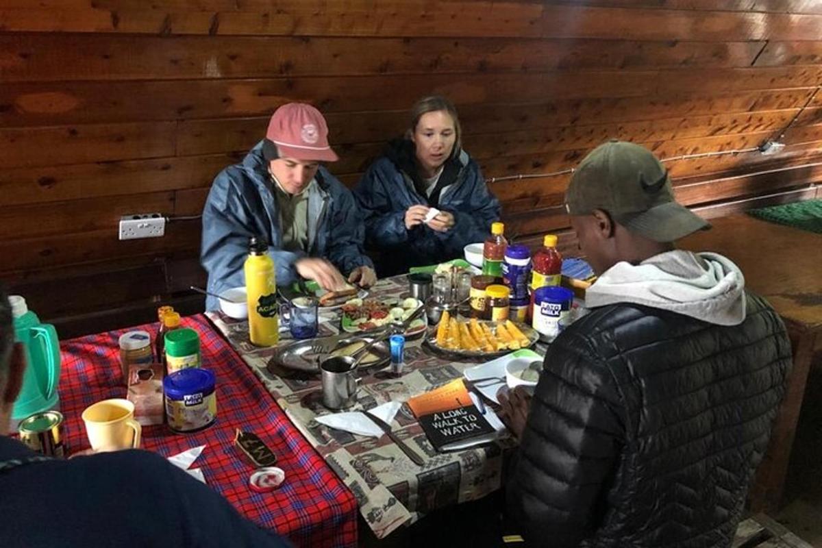 skupina lidí sedících kolem stolu s jídlem