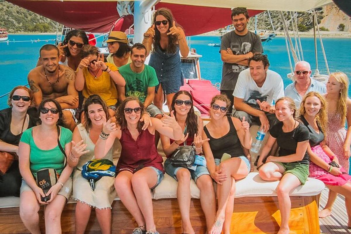 μια ομάδα ανθρώπων που κάθονται στο πίσω μέρος μιας βάρκας