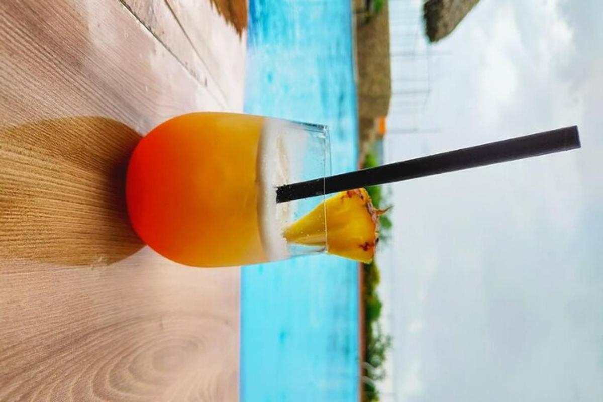 tangan seseorang memegang minuman pada sebatang kayu