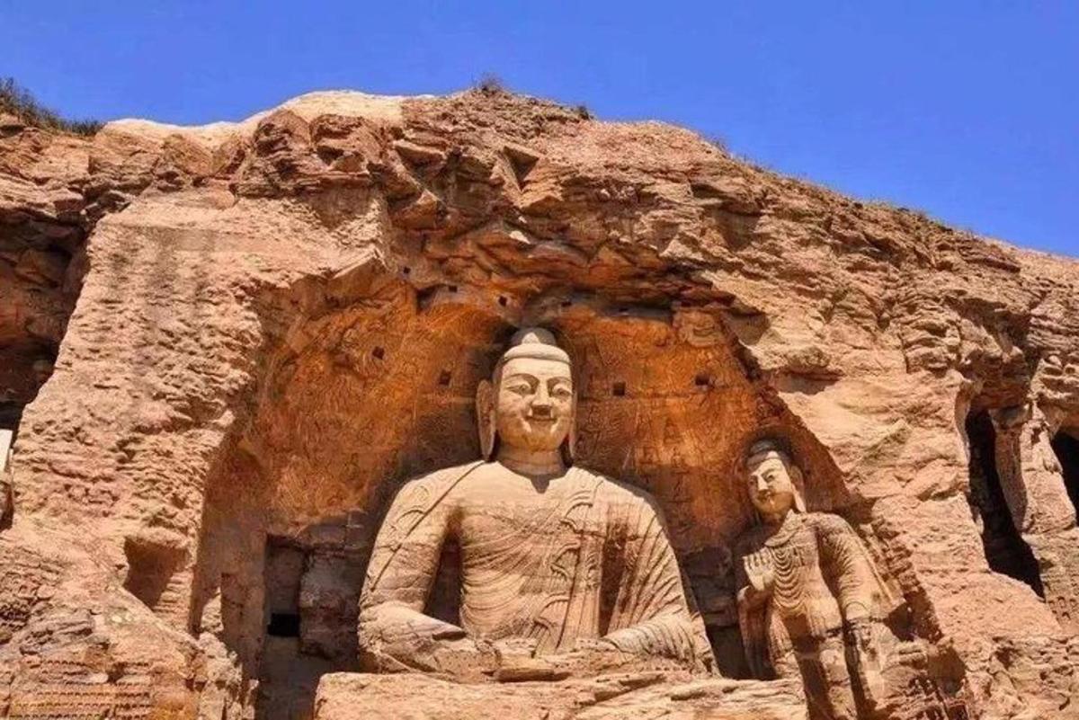 Una estatua de un hombre y una mujer frente a una montaña.