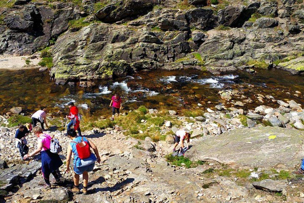 un grupo de personas caminando por una montaña rocosa