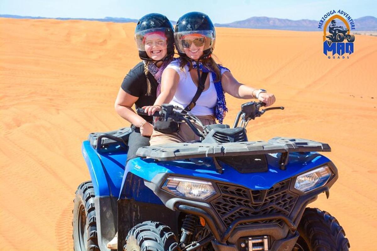 two women riding on a dirt bike in the desert