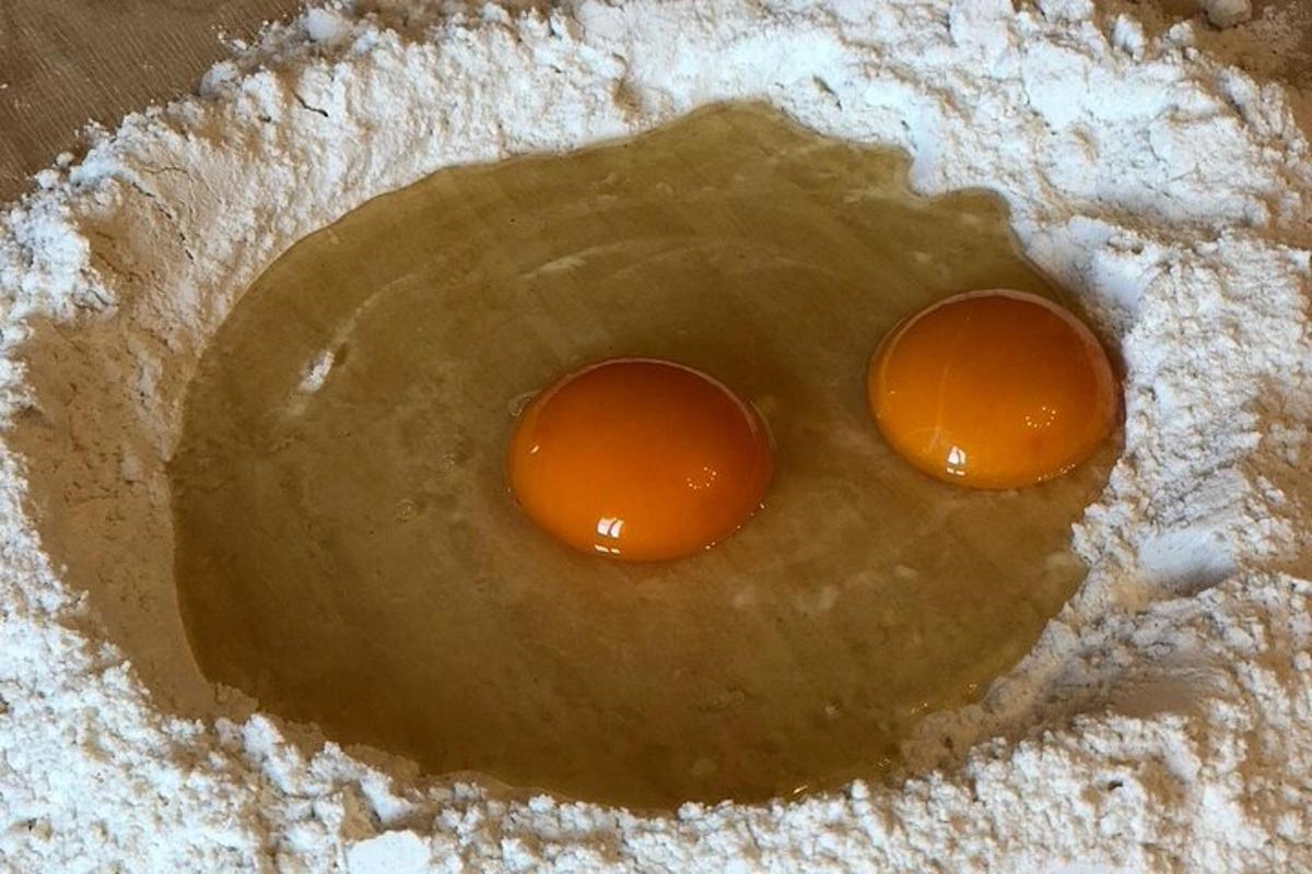 dvě vejce leží v misce mouky