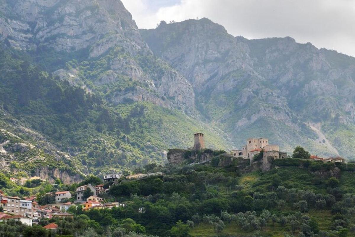 un villaggio su una collina con le montagne sullo sfondo