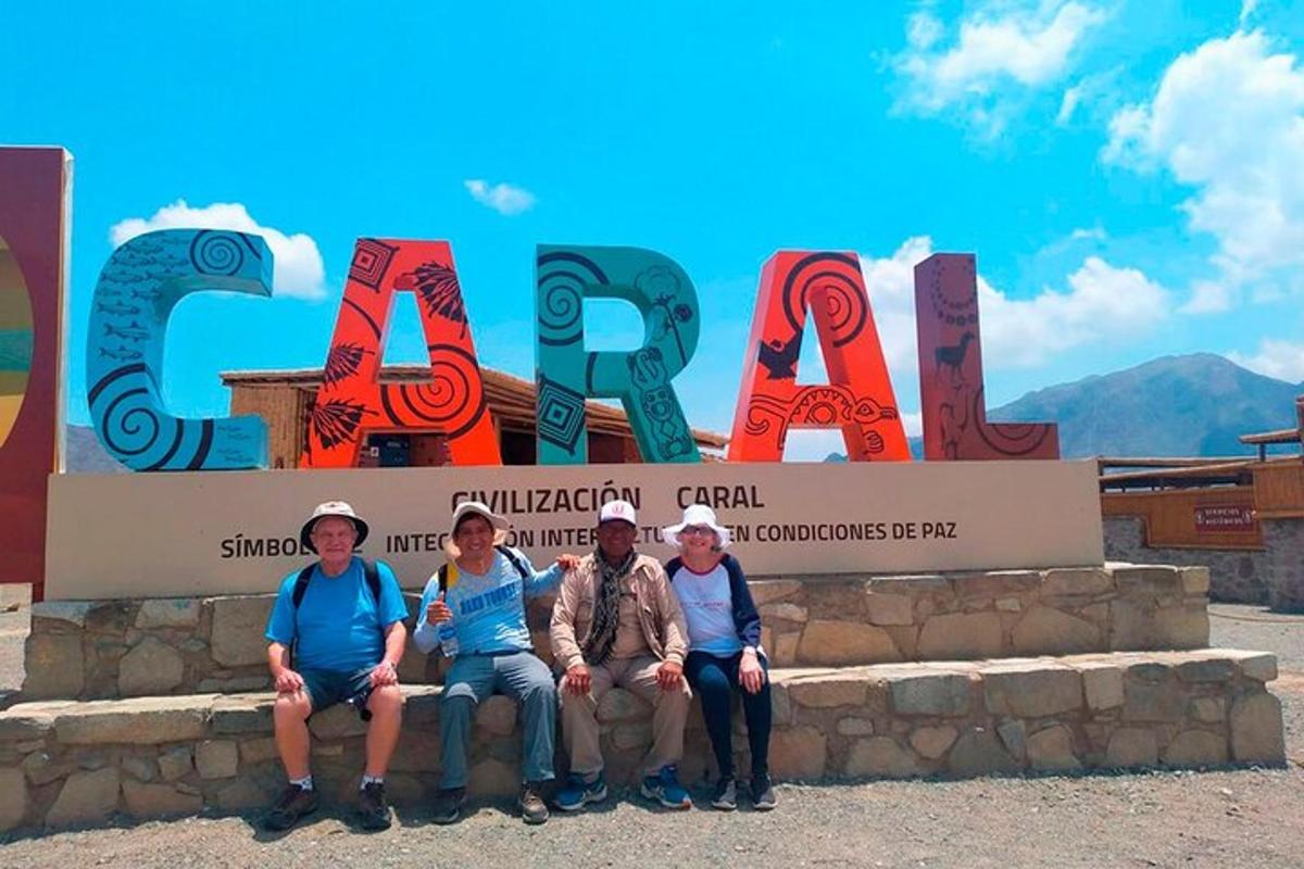 um grupo de pessoas sentadas em frente a uma placa