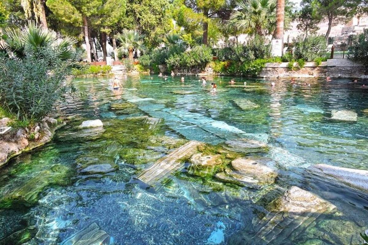 μια λίμνη με νερό στην οποία κολυμπούν άνθρωποι