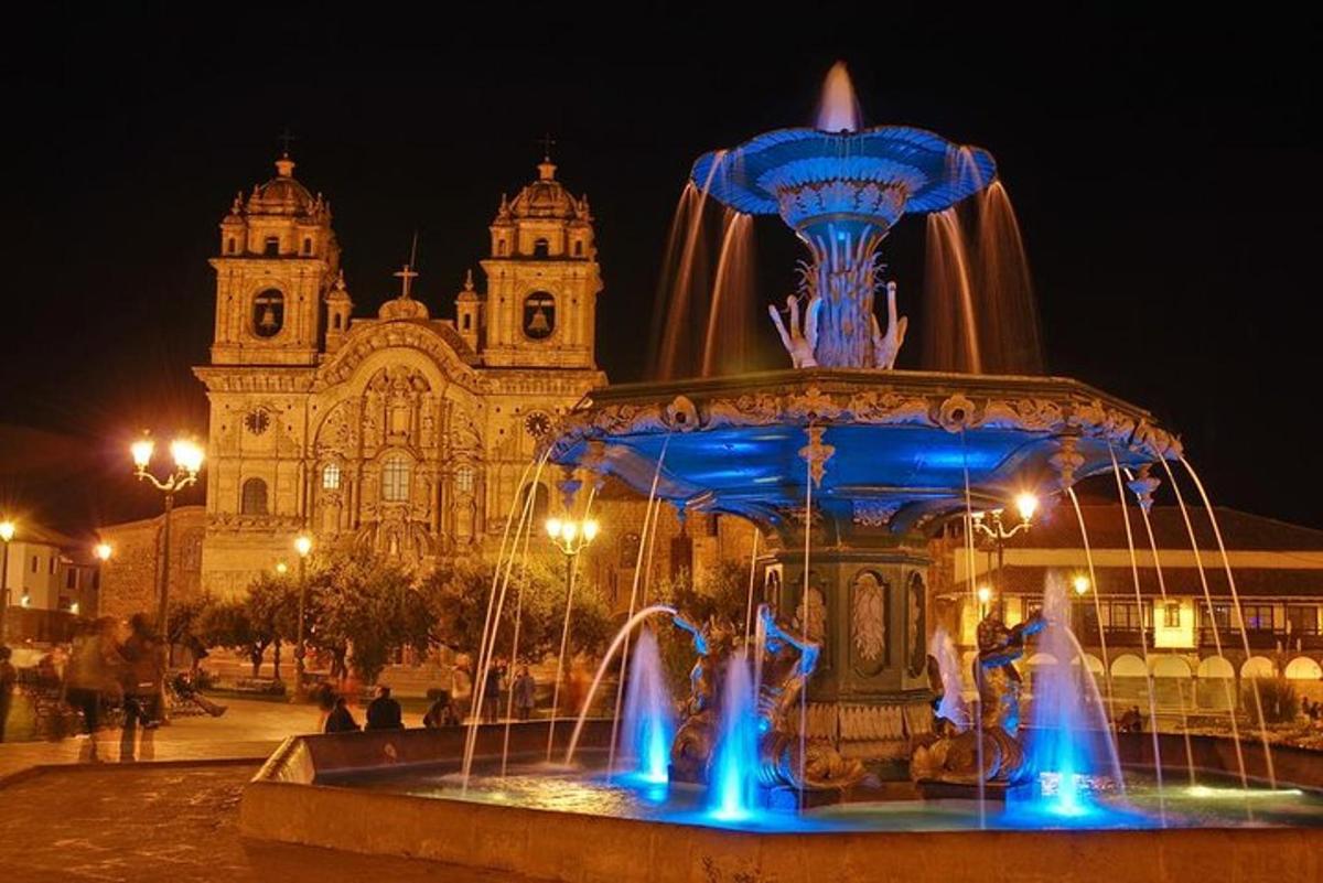 a fountain with blue lights in front of a building