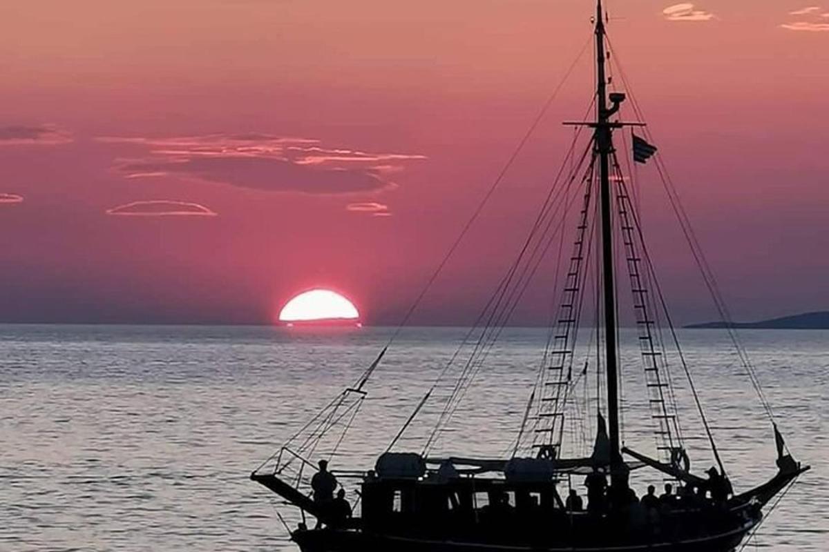 a boat in the ocean with a sunset in the background