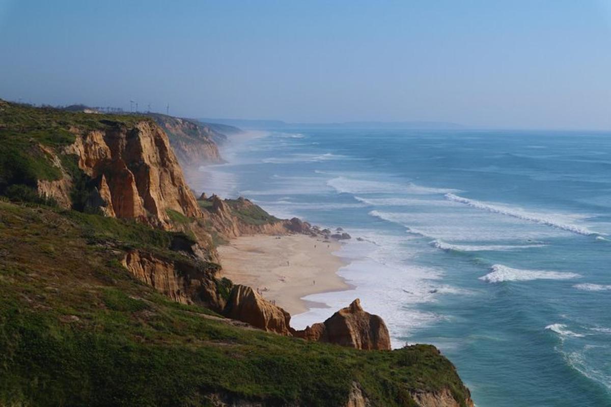 a view of the ocean and a beach on a cliff