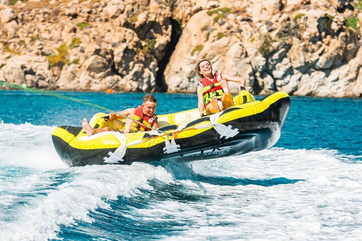due persone con giubbotti di salvataggio su un gommone in acqua