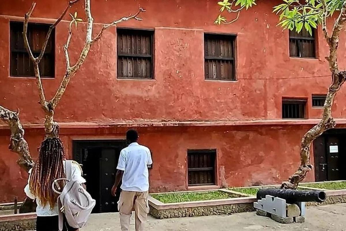 a man and a woman standing in front of a red building