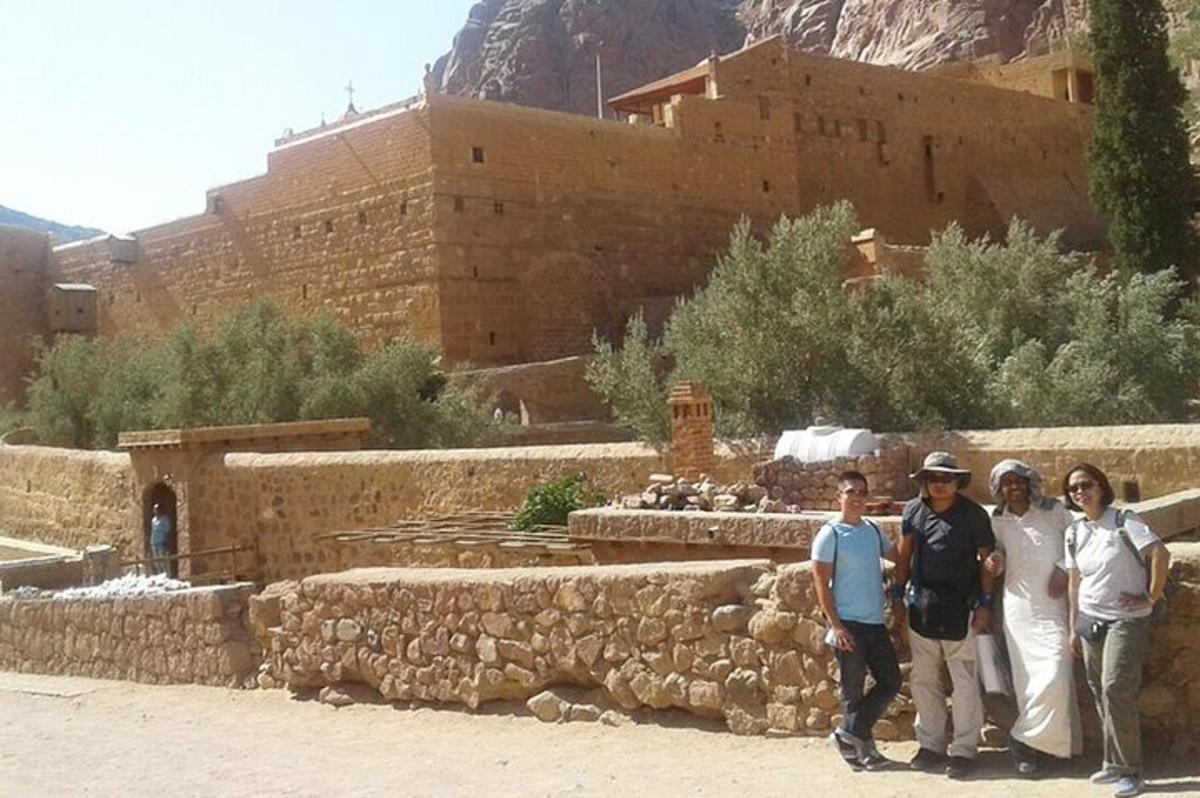 un gruppo di persone in piedi davanti a un muro di pietra
