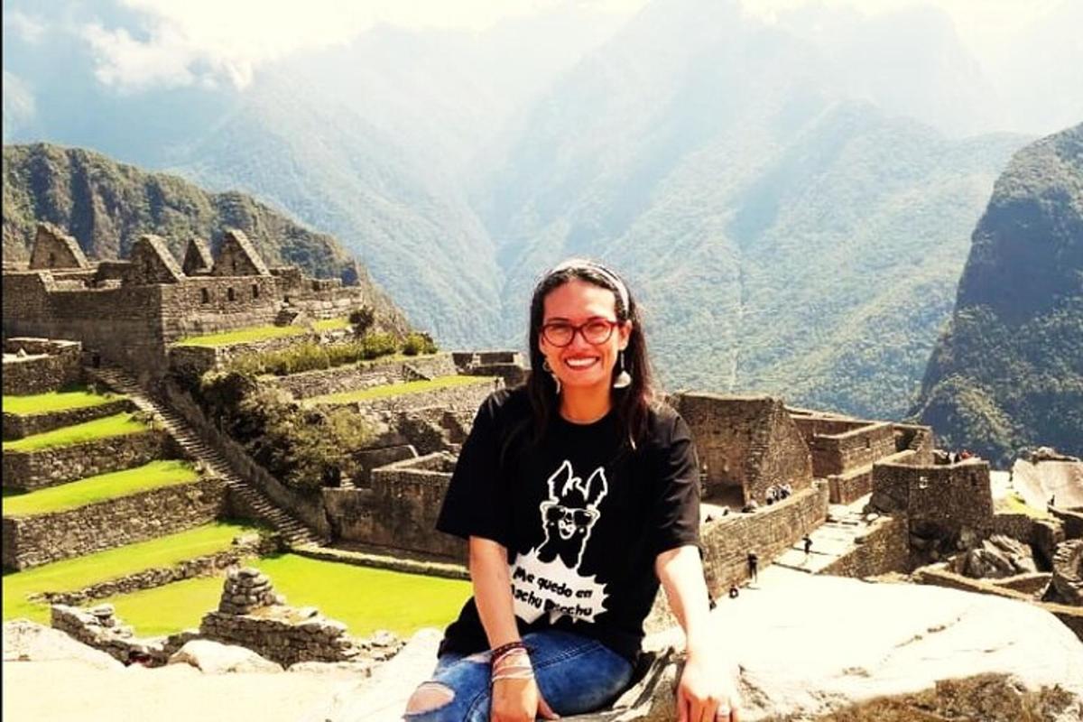 un uomo seduto sul bordo delle rovine di Machu Picchu