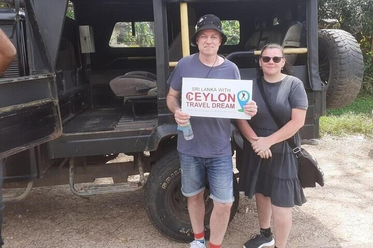 a man and woman holding a sign in front of a truck