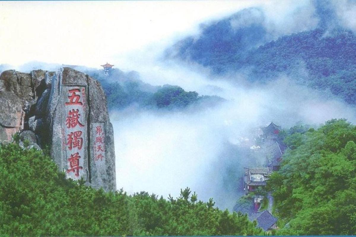 a misty mountain with a sign on top of it