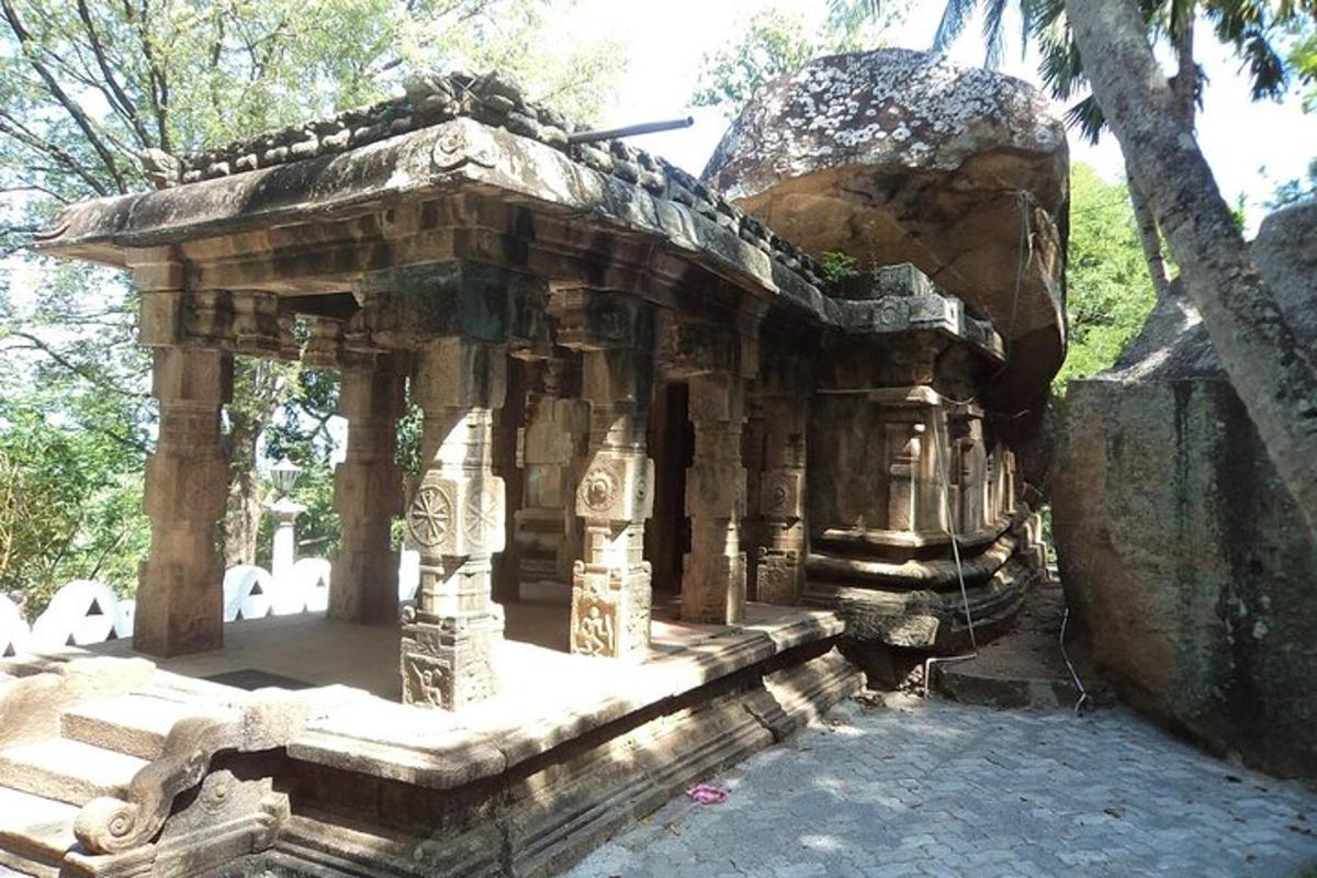 a small stone building with a large rock