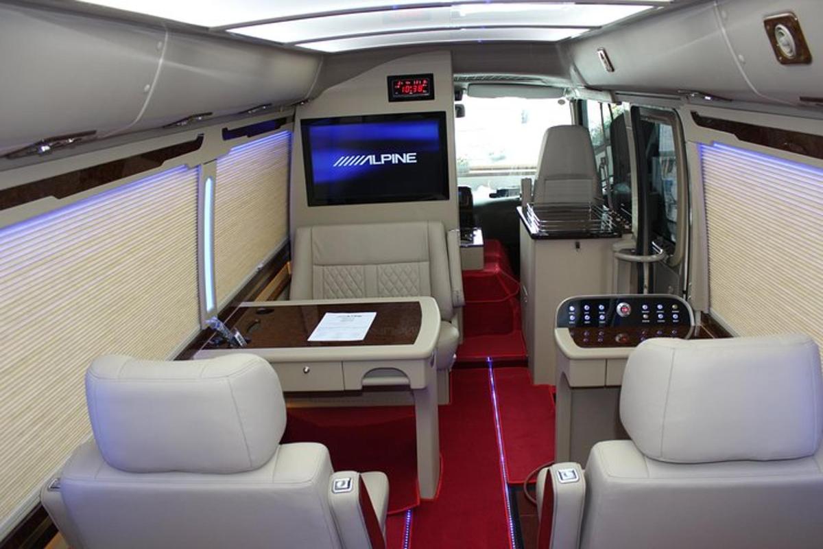 an interior of a bus with two chairs and a tv