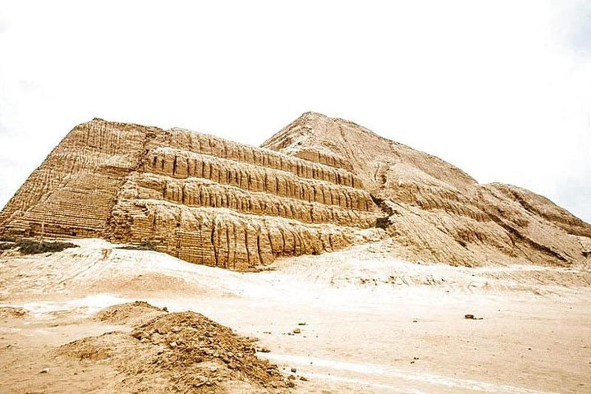 a large mound of sand next to a pyramid