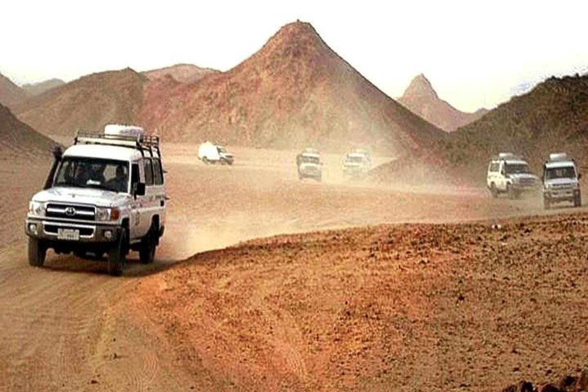 un gruppo di auto che percorrono una strada sterrata