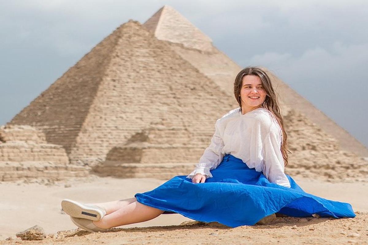 žena sedící před pyramidami