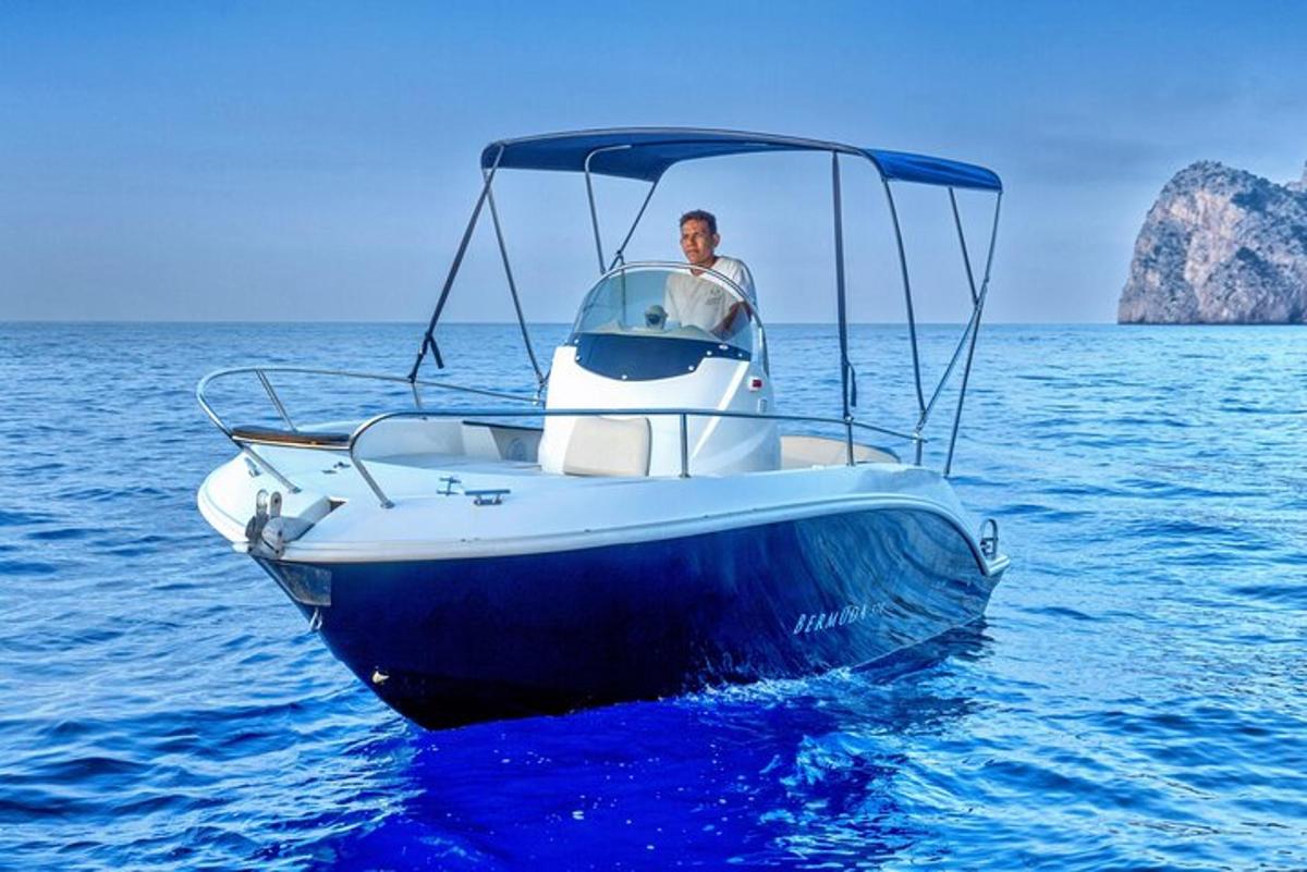 Un hombre en un bote azul y blanco en el agua.