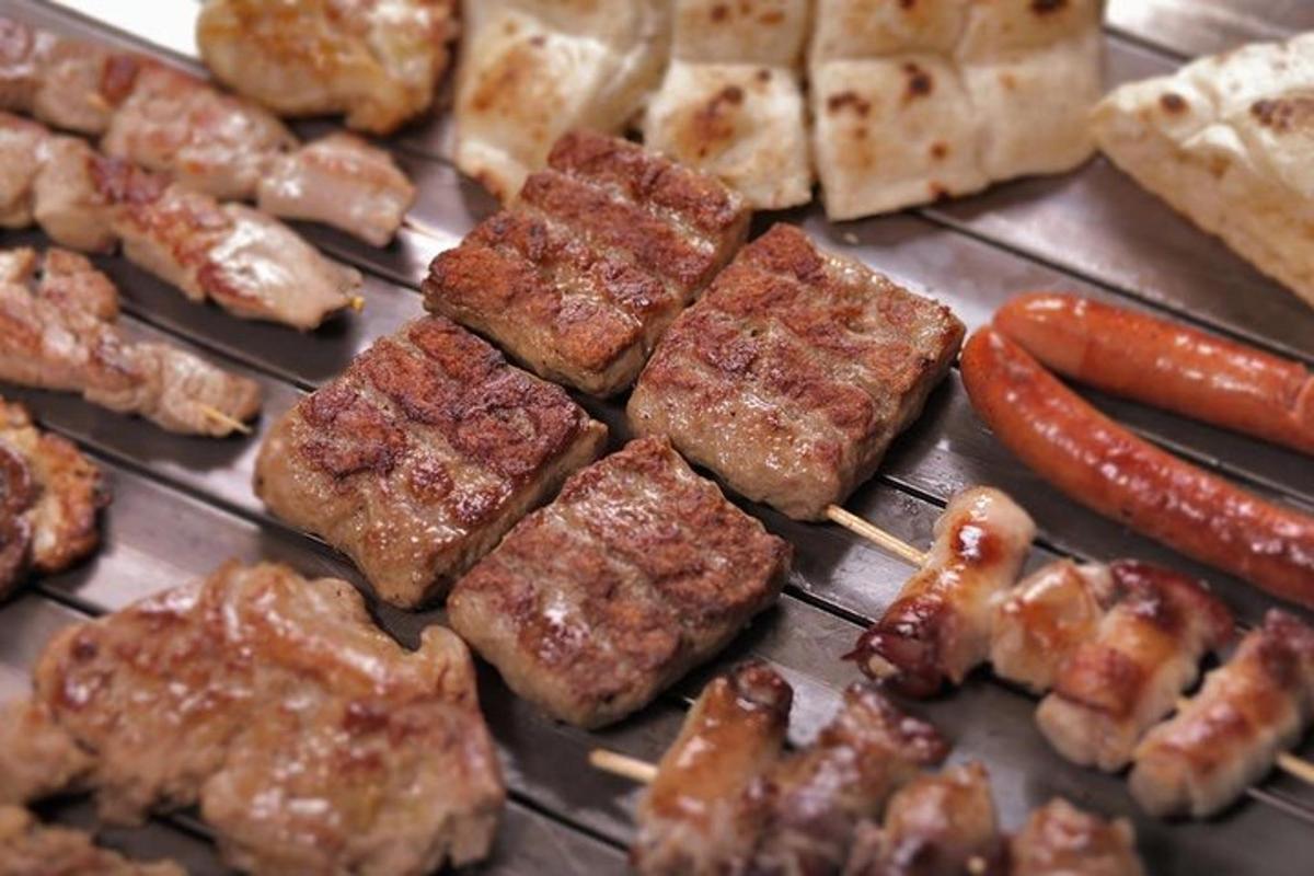 a grill with meat and hot dogs and bread