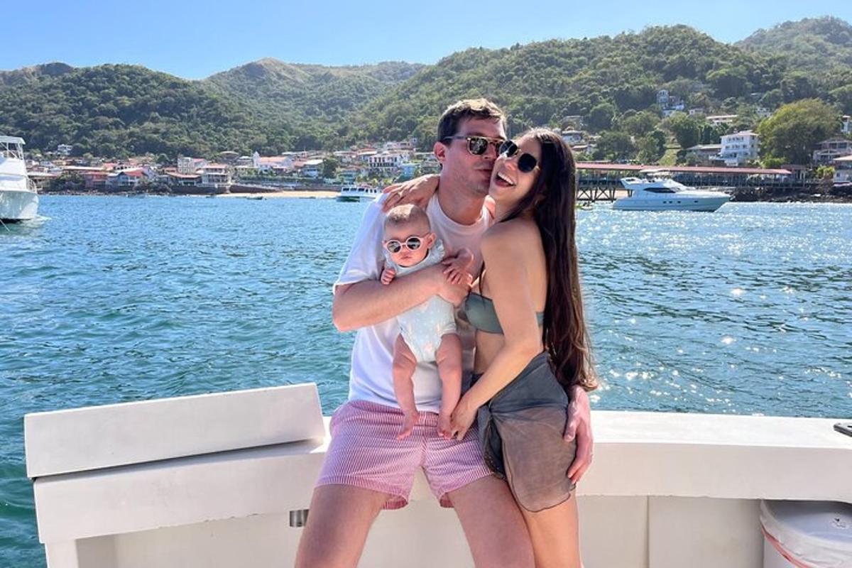 un uomo e una donna che tengono in braccio un bambino su una barca