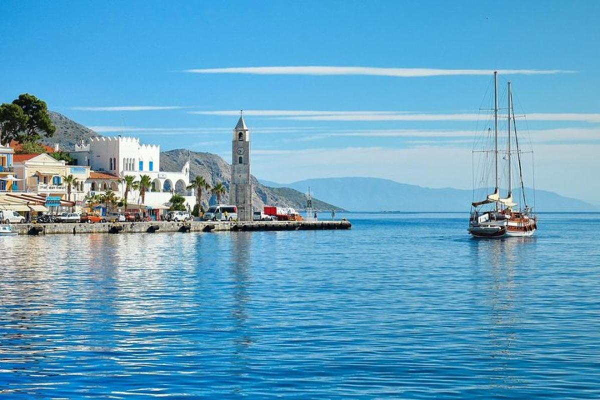 μια βάρκα στο νερό δίπλα σε μια πόλη με έναν πύργο ρολογιού