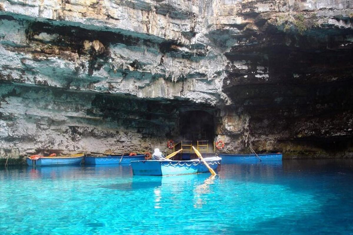 a boat in the water in front of a cave