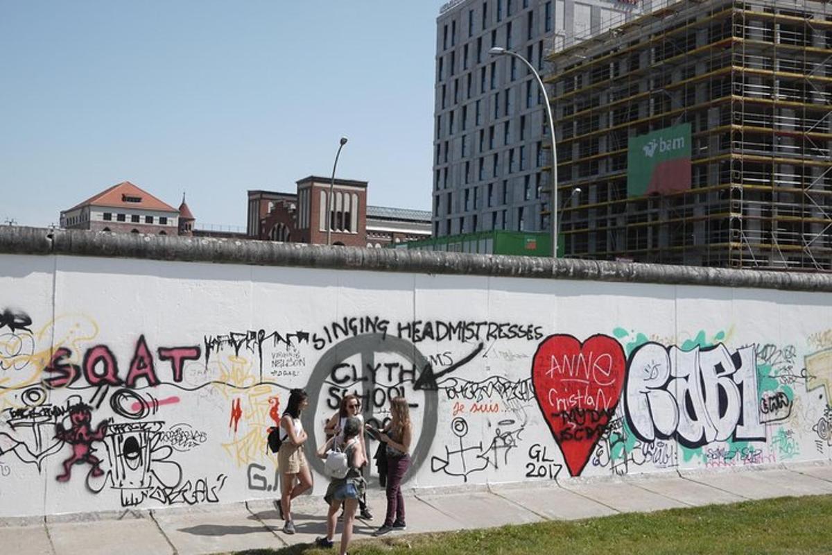 un gruppo di persone in piedi davanti a un muro con graffiti