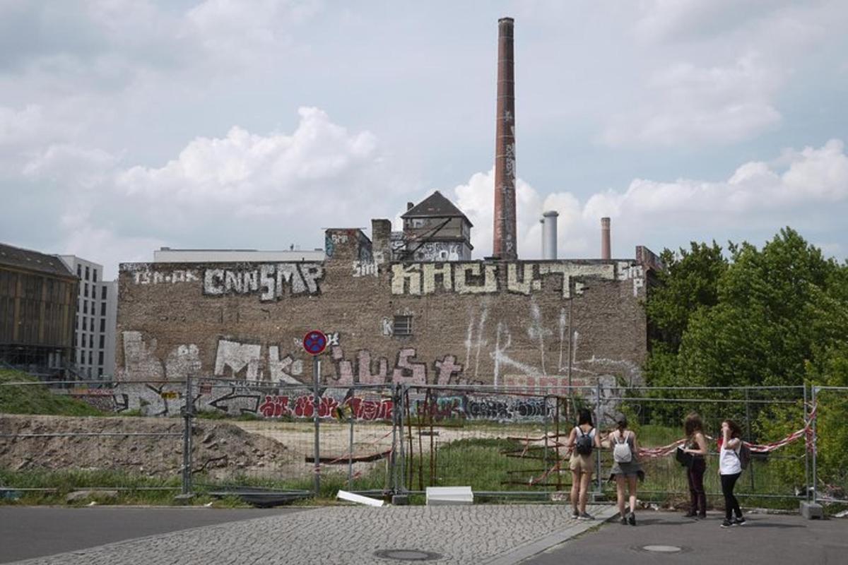 un gruppo di persone in piedi davanti a un edificio con graffiti