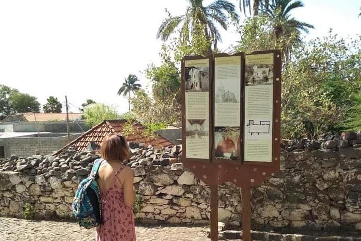 a woman looking at a sign at a zoo