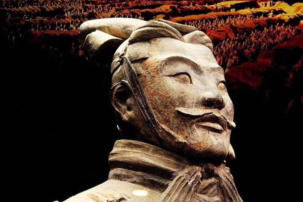 a statue of a face with a crowd behind it