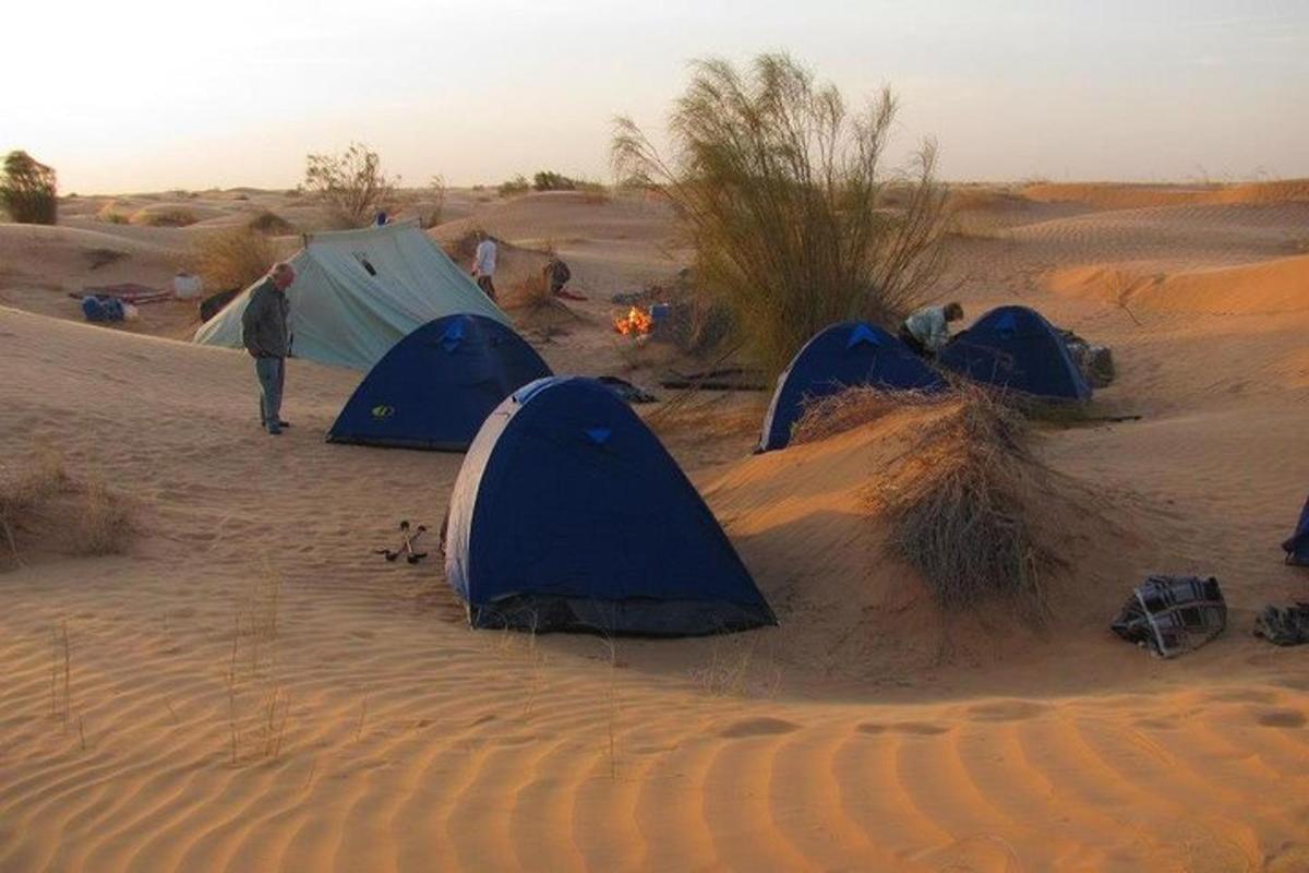 a group of tents in the desert with a fire