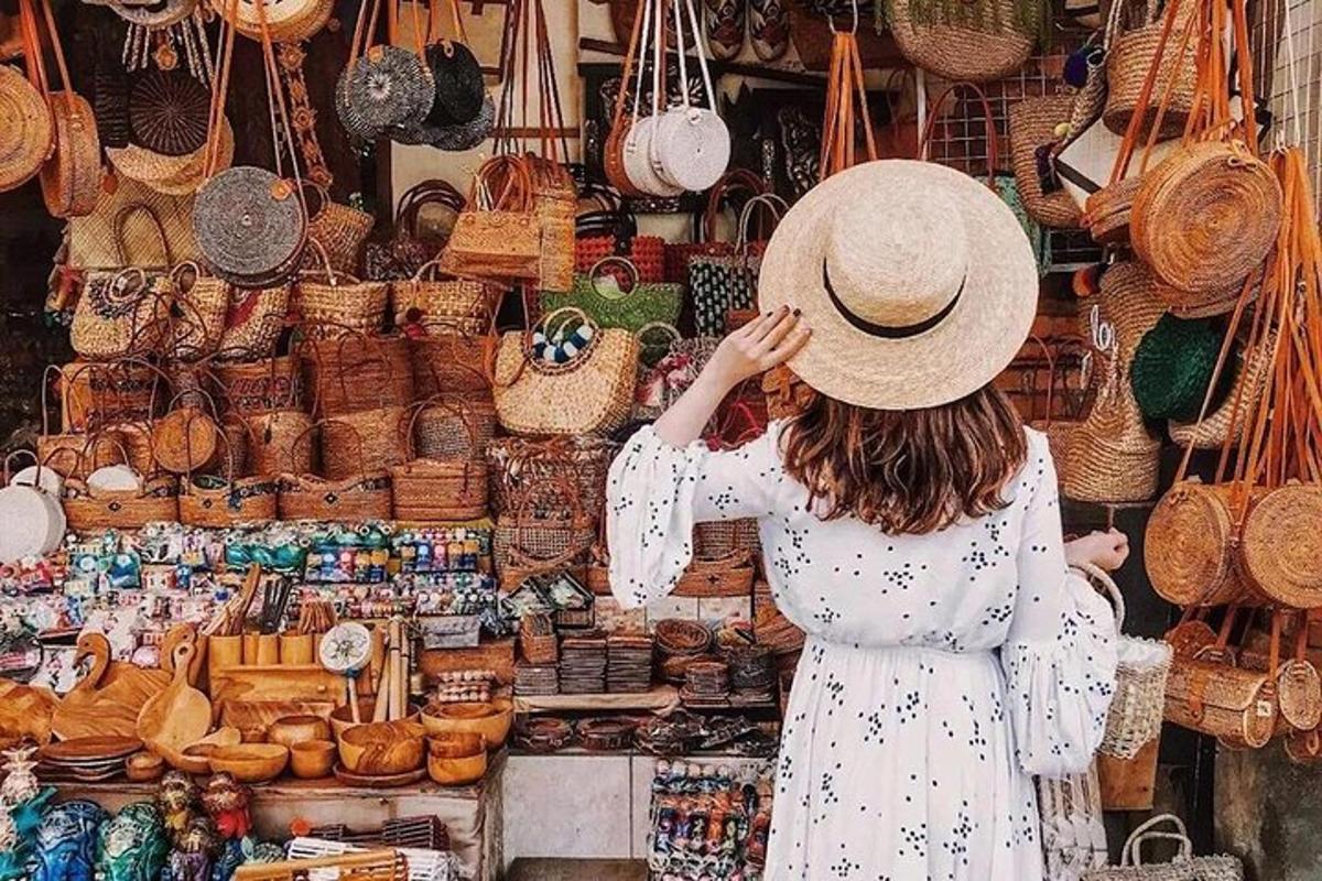 a woman wearing a hat standing in front of a market