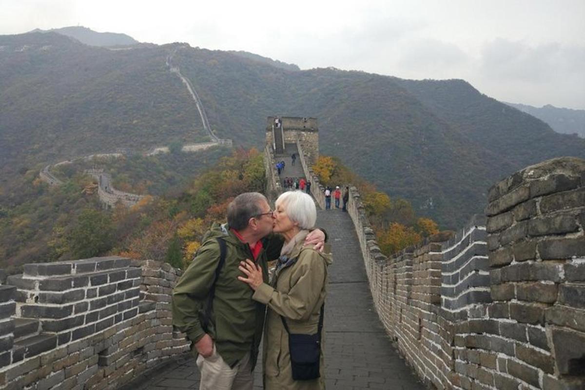a man and woman kissing on the great wall