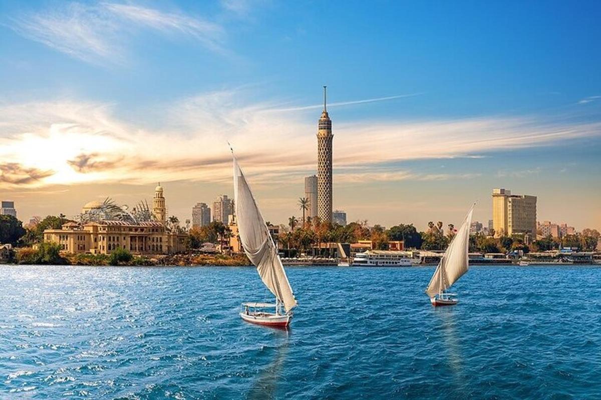 two sailboats in the water with a city in the background