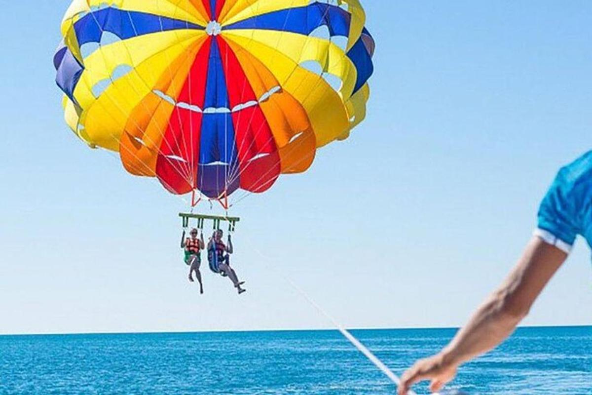 một người đàn ông đang bay một chiếc dù đầy màu sắc trên đại dương