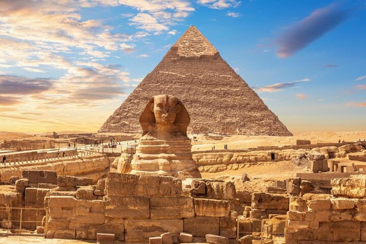 uma estátua de leão em frente às pirâmides